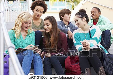 High School Students Sitting Outside Building With Phones View Large Photo Image Stock Photograph - High School Students Sitting Outside Building With Phones. Fotosearch