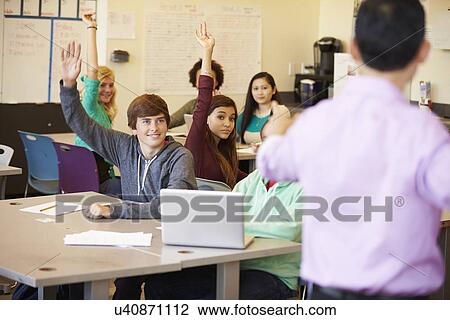 Stock Image - High School Students With Teacher In Class Using Laptops. Fotosearch