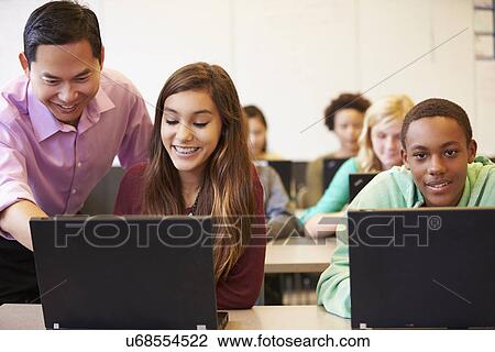 Stock Image - High School Students With Teacher In Class Using Laptops. Fotosearch
