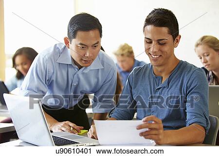Stock Image - High School Students With Teacher In Class Using Laptops. Fotosearch