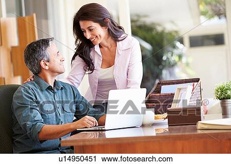 Hispanic Couple Using Laptop On Desk At Home View Large Photo Image Stock Image - Hispanic Couple Using Laptop On Desk At Home. Fotosearch