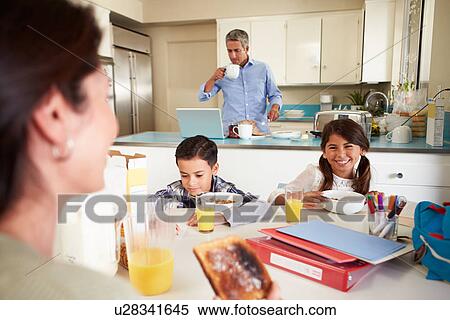 Stock Photography - Hispanic Family Eating Breakfast At Home Before School. Fotosearch