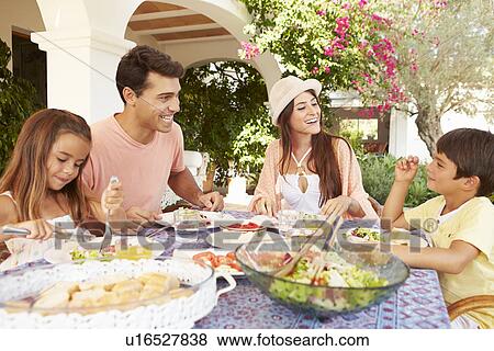 Hispanic Family Enjoying Outdoor Meal At Home Together View Large Photo Image Stock Photo - Hispanic Family Enjoying Outdoor Meal At Home Together. Fotosearch