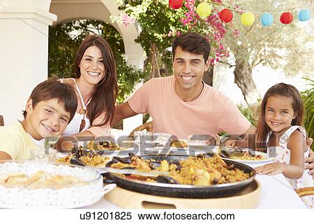 Stock Photography - Hispanic Family Enjoying Outdoor Meal At Home Together. Fotosearch