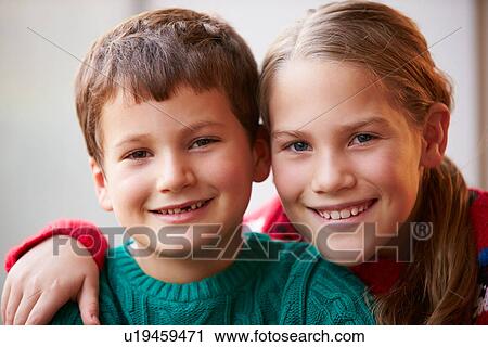 Stock Image - Indoor Portrait Of Brother And Sister. Fotosearch