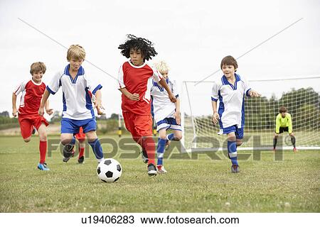 Stock Image - Junior 5 a side teams playing football. Fotosearch