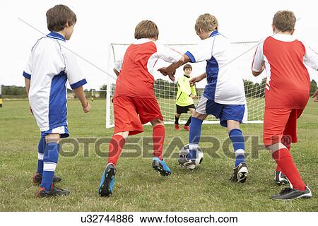 Stock Photograph - Junior 5 a side teams playing football. Fotosearch