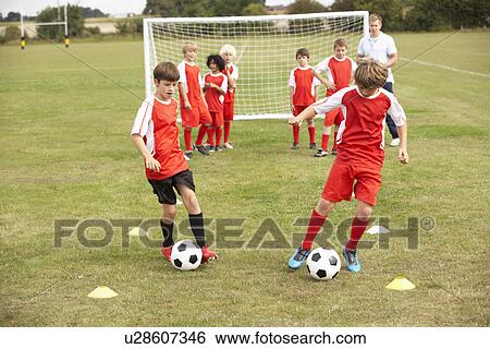 Stock Photograph - Junior football team training with coach. Fotosearch