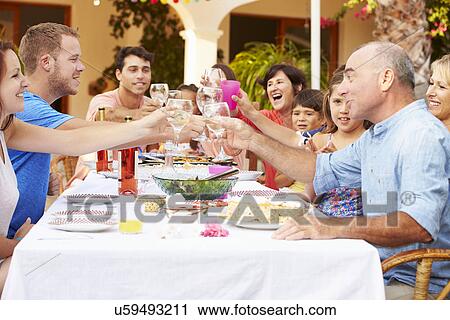 Stock Image - Large Family Group Celebrating Birthday On Terrace Together. Fotosearch