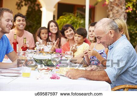 Stock Photo - Large Family Group Celebrating Birthday On Terrace Together. Fotosearch