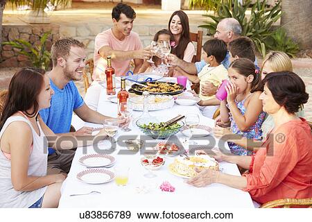 Stock Photo - Large Family Group Enjoying Meal On Terrace Together. Fotosearch