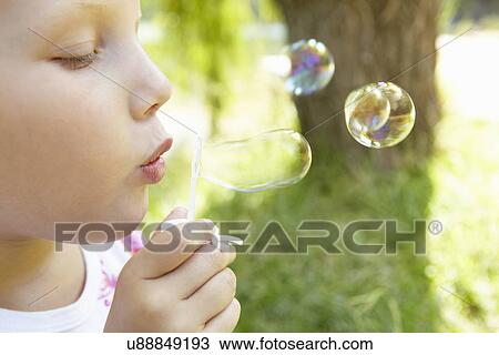 Little girl blowing bubbles outdoors View Large Photo Image Stock Image - Little girl blowing bubbles outdoors. Fotosearch