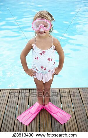 Stock Image - Little girl by outdoor swimming pool. Fotosearch