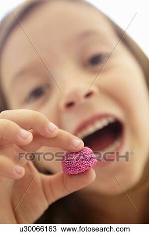 Stock Image - Little girl eating candy. Fotosearch