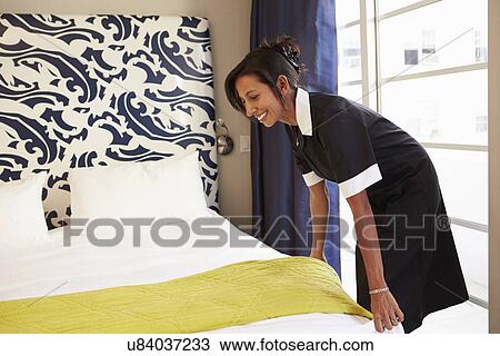 Maid Tidying Hotel Room And Making Bed View Large Photo Image Stock Image - Maid Tidying Hotel Room And Making Bed. Fotosearch