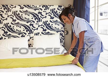 Maid Tidying Hotel Room And Making Bed View Large Photo Image Stock Photo - Maid Tidying Hotel Room And Making Bed. Fotosearch