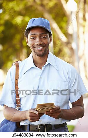 Mailman Walking Along Street Delivering Letters View Large Photo Image Picture - Mailman Walking Along Street Delivering Letters . Fotosearch