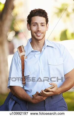 Mailman Walking Along Street Delivering Letters View Large Photo Image Stock Photo - Mailman Walking Along Street Delivering Letters . Fotosearch