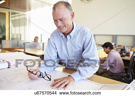 Male Architect Studying Plans In Office View Large Photo Image Picture - Male Architect Studying Plans In Office. Fotosearch