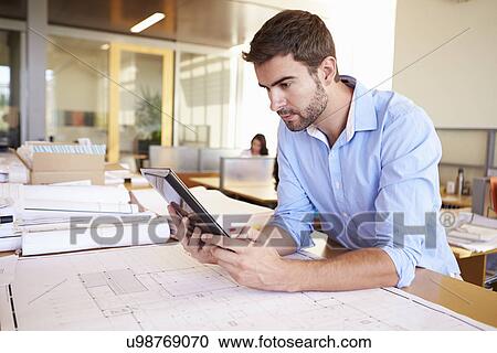 Male Architect With Digital Tablet Studying Plans In Office View Large Photo Image Stock Image - Male Architect With Digital Tablet Studying Plans In Office. Fotosearch
