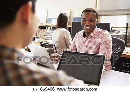 Stock Photograph - Male Architect Working At Desk On Laptop. Fotosearch