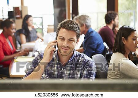 Male Architect Working At Desk With Meeting In Background View Large Photo Image Stock Photograph - Male Architect Working At Desk With Meeting In Background. Fotosearch