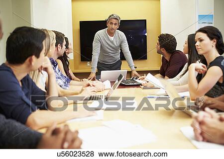 Male Boss Addressing Meeting Around Boardroom Table View Large Photo Image Stock Photo - Male Boss Addressing Meeting Around Boardroom Table. Fotosearch