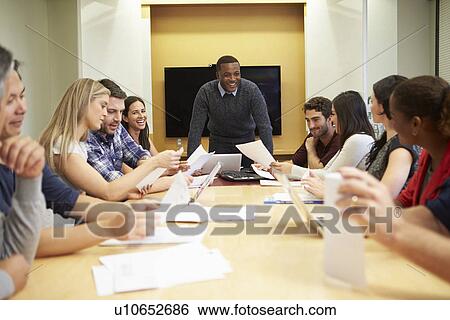 Male Boss Addressing Meeting Around Boardroom Table View Large Photo Image Stock Photograph - Male Boss Addressing Meeting Around Boardroom Table. Fotosearch