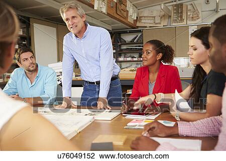 Male Boss Leading Meeting Of Architects Sitting At Table View Large Photo Image Stock Image - Male Boss Leading Meeting Of Architects Sitting At Table. Fotosearch