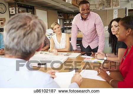 Male Boss Leading Meeting Of Architects Sitting At Table View Large Photo Image Stock Photo - Male Boss Leading Meeting Of Architects Sitting At Table. Fotosearch