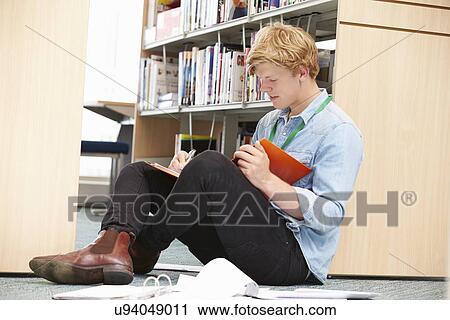 Stock Image - Male College Student Studying In Library. Fotosearch
