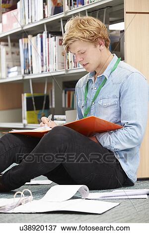 Stock Photo - Male College Student Studying In Library. Fotosearch