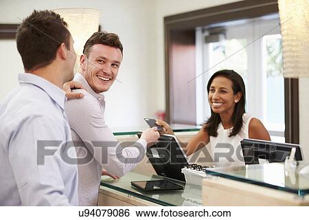Male Couple Checking In At Hotel Reception View Large Photo Image Stock Photograph - Male Couple Checking In At Hotel Reception. Fotosearch