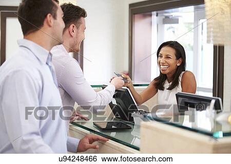 Male Couple Checking In At Hotel Reception View Large Photo Image Stock Photograph - Male Couple Checking In At Hotel Reception. Fotosearch