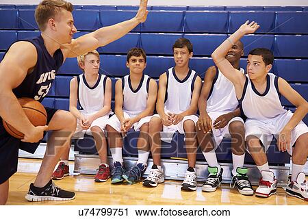 Stock Image - Male High School Basketball Team Having Team Talk With Coach. Fotosearch