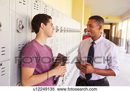 Male High School Student Talking To Teacher By Lockers View Large Photo Image Stock Photography - Male High School Student Talking To Teacher By Lockers. Fotosearch
