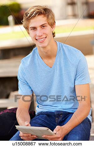 Stock Photo - Male High School Student Using Digital Tablet Outdoors. Fotosearch
