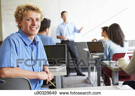 Stock Photo - Male High School Student Using Laptop In Classroom. Fotosearch