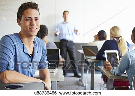 Stock Photograph - Male High School Student Using Laptop In Classroom. Fotosearch
