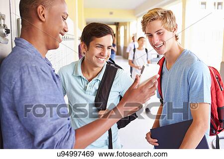 Stock Photo - Male High School Students By Lockers Looking At Mobile Phone. Fotosearch