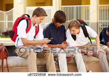 Male High School Students Using Mobile Phones On School Campus View Large Photo Image Stock Photo - Male High School Students Using Mobile Phones On School Campus . Fotosearch