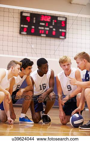 Picture - Male High School Volleyball Team Having Team Talk From Coach. Fotosearch