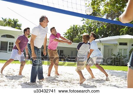 Stock Image - Male Multi Generation Family Playing Volleyball In Garden. Fotosearch