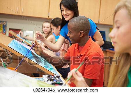 Stock Photography - Male Pupil In High School Art Class With Teacher. Fotosearch