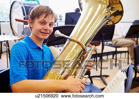 Stock Image - Male Pupil Playing Tuba In High School Orchestra. Fotosearch