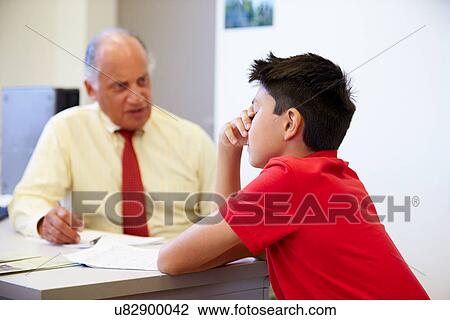 Stock Image - Male Student Talking To High School Counselor. Fotosearch