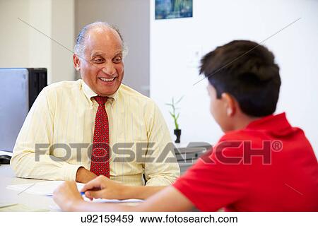Stock Photo - Male Student Talking To High School Counselor. Fotosearch