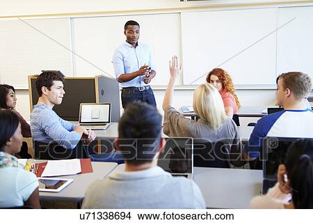 Picture - Male Tutor Teaching University Students In Classroom. Fotosearch