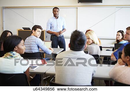 Stock Photograph - Male Tutor Teaching University Students In Classroom. Fotosearch