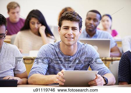 Stock Photograph - Male University Student Using Digital Tablet In Lecture. Fotosearch